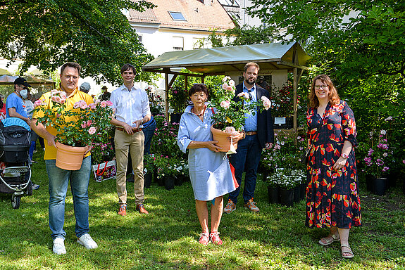 Mit einem Rosenstock der Sorte "Rosenstadt Freising" wurde Heidi Kammler (rechts) als Grünlandreferentin verabschiedet und ihr Nachfolger Robert Weller (links) offiziell begrüßt - beiden wünschten Andreas Mehltretter, OB Tobias Eschenbacher und Julia Bönig (v.l.) alles Gute. (Foto: Stadt Freising)