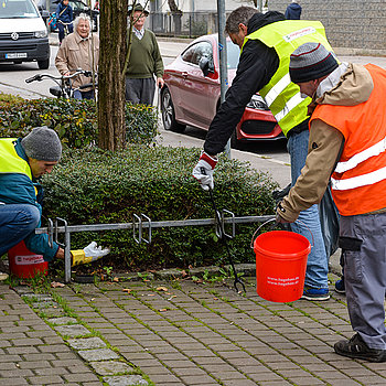Mit Teamarbeit lassen sich selbst dicht verzweigte Gebüsche und enge Pflasterstein-Fugen vom Müll befreien. (Foto: Stadt Freising)