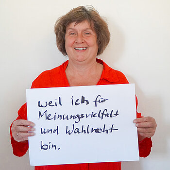 Stadtratsmitglied Charlotte Reitsam. Foto: Stadt Freising Eine Frau in einem orangenen Hemd zeigt ein Schild mit der Aufschrift "weil ich für Meinungsvielfalt und Wahlrecht bin."