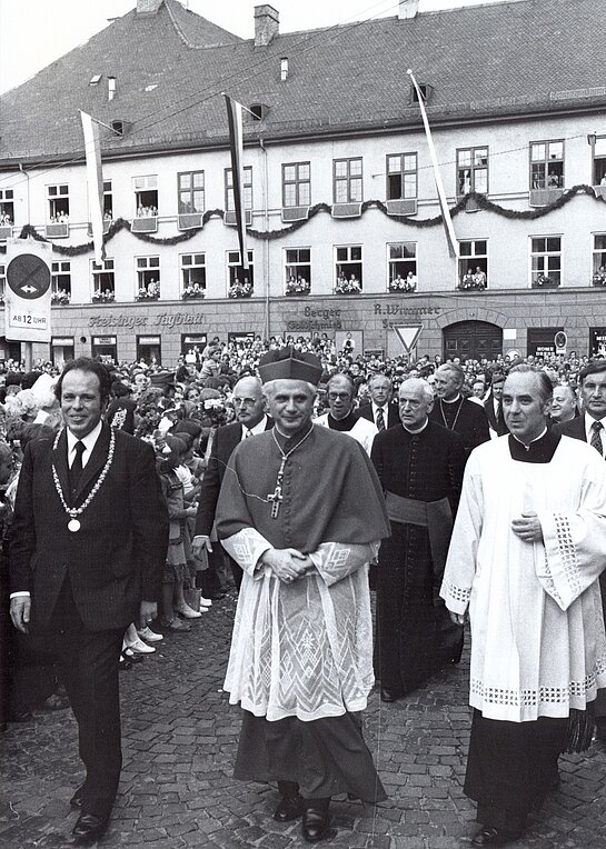 Erzbischof Josef Ratzinger zusammen mit Oberbürgermeister Adolf Schäfer und Stadtpfarrer Walter Brugger auf dem Marienplatz am 24. Juni 1977. 