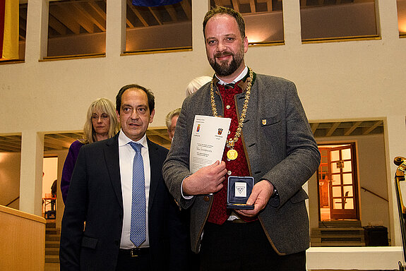 Bürgermeister Christan Béraud und OB Tobias Eschenbacher (v.l.), mit Urkunde und Stadtmedaille. (Foto: Stadt Freising)