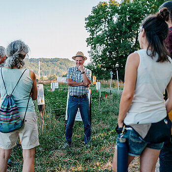 Mehrere Menschen stehen in einem Feld. 