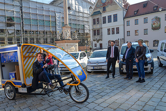 Probefahrt: Innenstadtkoordinator Michael Schulze testet das elektrisch betriebene Werbemobil, beobachtet von (v.l.) Stadtrat Franz Bernack, Bürgermeister Hans Hözl und Stadträtin Birgit Mooser-Niefanger. (Foto: Stadt Freising)