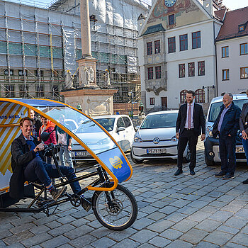 Probefahrt: Innenstadtkoordinator Michael Schulze testet das elektrisch betriebene Werbemobil, beobachtet von (v.l.) Stadtrat Franz Bernack, Bürgermeister Hans Hözl und Stadträtin Birgit Mooser-Niefanger. (Foto: Stadt Freising)