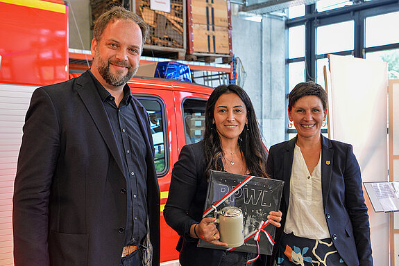 OB Tobias Eschenbacher und Susanne Günther (rechts) bedanken sich bei Feride Niedermeier mit einem Bierkrug und eine Platte von RPWL. 