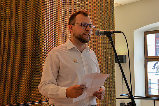 Das Foto zeigt Freising Kulturreferent Nico Heitz stehend vor einem Mikrofon.