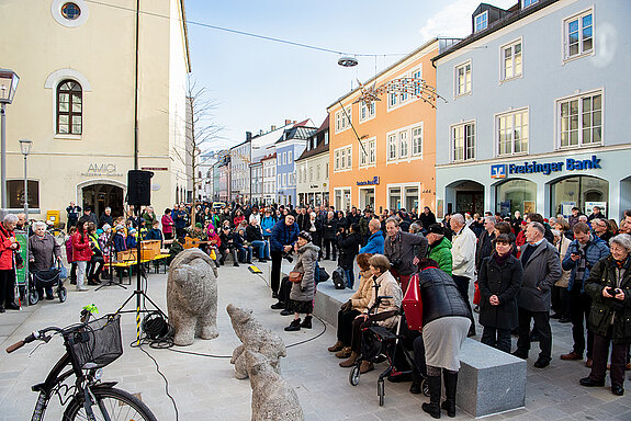 Blick auf den neuen Stadtplatz mit Bärengruppe, Granitsteinen zum Sitzen, die auch der Verkehrsberuhigungdienen, sowie der von Kindern und Gästen bevölkerten Rundbank um den neu gepflanzten Baum. (Foto: Stadt Freising)