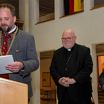 OB Tobias Eschenbacher verliest die Urkunde zur Verleihung der Partnerschaftsmedaille in Silber an seine Eminenz, Kardinal Reinhard Marx (v.l.). Foto: Stadt Freising