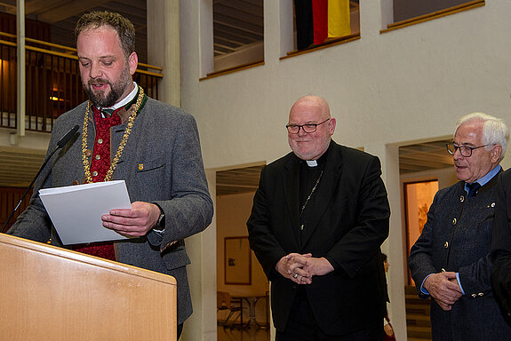 OB Tobias Eschenbacher verliest die Urkunde zur Verleihung der Partnerschaftsmedaille in Silber an seine Eminenz, Kardinal Reinhard Marx (v.l.). Foto: Stadt Freising