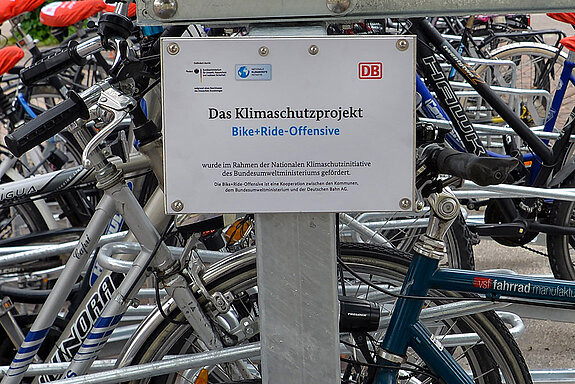 Mit Schildern an der Fahrradabstellanlage wird darauf hingewiesen, dass es sich um ein Klimaschutzprojekt der Bike+Ride-Offensive handelt. (Foto: Stadt Freising)
