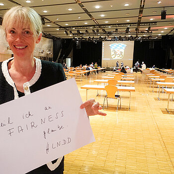 Bürgermeisterin Birgit Mooser-Niefanger hält ein Schild mit der Aufschrift: "weil ich an FAIRNESS glaube. #LNDD""