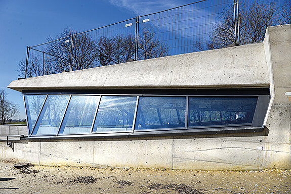 Das Bild zeigt das südliche Ende des Tunnelportals in einer Seitenansicht von außen mit der Schutzverglasung. (Foto: Stadt Freising)