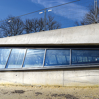 Das Bild zeigt das südliche Ende des Tunnelportals in einer Seitenansicht von außen mit der Schutzverglasung. (Foto: Stadt Freising)