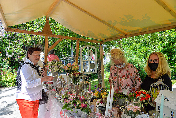 Bürgermeisterin Eva Bönig (links) interessiert sich für die (rosigen) Wohn- und Gartenaccessoires sowie Geschenke, die ein Stand auf der Roseninsel feilbot. (Foto: Stadt Freising)