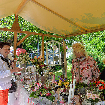 Bürgermeisterin Eva Bönig (links) interessiert sich für die (rosigen) Wohn- und Gartenaccessoires sowie Geschenke, die ein Stand auf der Roseninsel feilbot. (Foto: Stadt Freising)
