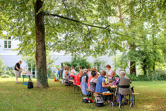 Auf dem Bild ist ein Freising frühstückt im Amtsgerichtsgarten zu sehen.