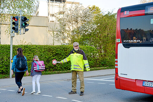 Ehrenamtliche Helfer*innen wie Norbert May an der Rotkreuzstra&szlig;e unterst&uuml;tzen Kinder dabei, sicher zur Schule und wieder nach Hause zu kommen. (Foto: Stadt Freising)