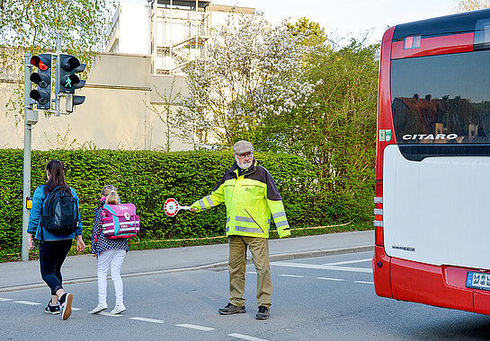 Ehrenamtliche Helfer*innen wie Norbert May an der Rotkreuzstra&szlig;e unterst&uuml;tzen Kinder dabei, sicher zur Schule und wieder nach Hause zu kommen. (Foto: Stadt Freising)