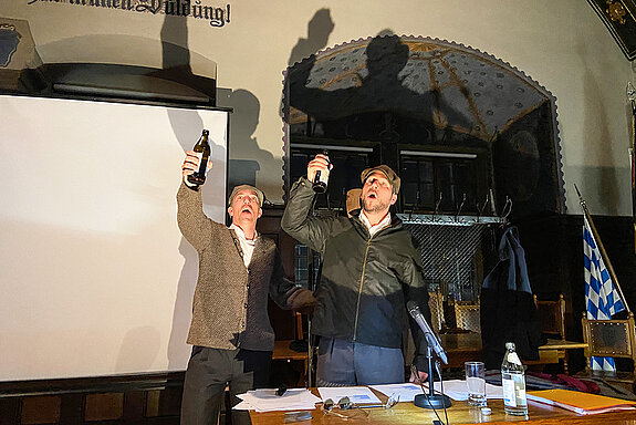 Zwei Männer, die Bierflaschen erheben.