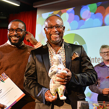 Der 1. Platz beim Interkulturellen Preis: Auf dem Bild sind die Vertreter Yerima Halirou und Deo Amados vom A.T.F. e. V., dem Verein der Freisinger Togoer zu sehen. 