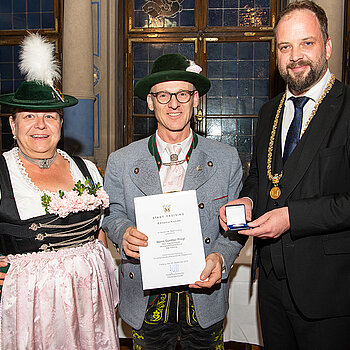 OB Tobias Eschenbacher zeichnet Günther Progl (Mitte) aus. (Foto: Stadt Freising)