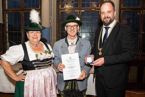 OB Tobias Eschenbacher zeichnet Günther Progl (Mitte) aus. (Foto: Stadt Freising)