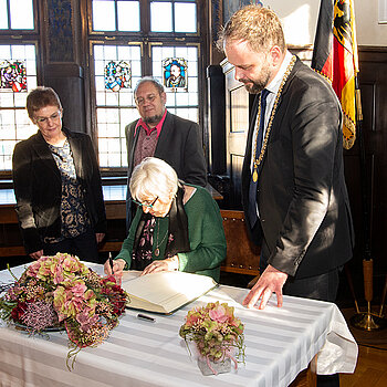 Eintrag ins goldene Buch (von links): Christa Eggerdinger und Guido Hoyer (beide VVN/BdA), Ehrengast Esther Bejarano und OB Tobias Eschenbacher. (Foto: Stadt Freising)