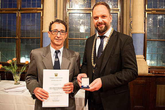 OB Tobias Eschenbacher zeichnet Konrad Deischl aus. (Foto: Stadt Freising)