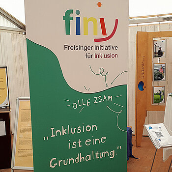 Ein Rollup in grün und weißß mit dem sehr bunten fini-Logo "Inklusion ist eine Grundhaltung"