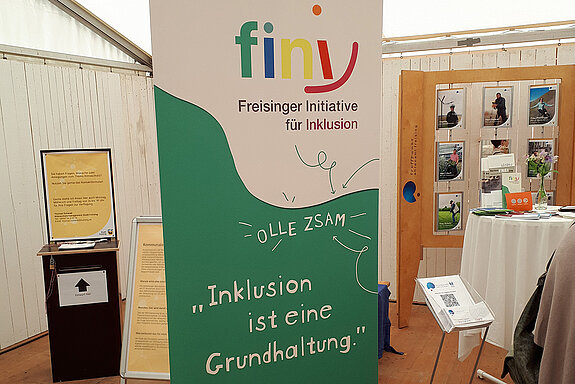 Ein Rollup in grün und weißß mit dem sehr bunten fini-Logo "Inklusion ist eine Grundhaltung"