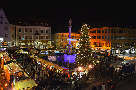 Der caritative Christkindlmarkt am Marienplatz Freising bei Nacht, farbig illuminiert. 