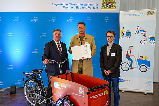 Urkundenübergabe zum Abschluss des Modellprojekts in München: Verkehrsminister Christian Bernreiter, Stadtrat Karl-Heinz Freitag (Mobilitätsreferent) und Dominik Fuchs, Mobilitätsbeauftragter der Stadt Freising (v.l., Foto: StMB/Winszczyk).