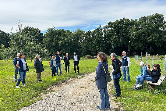 Menschen stehen auf beiden Seiten eines Kiesweges