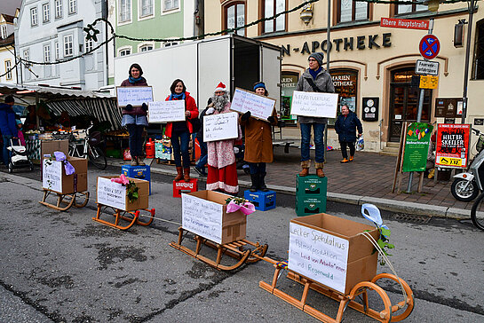 Aktivist*innen fordern auf der Straße mit Plakaten ein Lieferkettengesetz für verantwortungsvollen und fairen Handel.