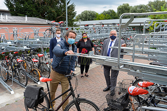 Mobilitätsreferent Karl-Heinz Freitag zeigt ein weiteres Mal, wie einfach auch das „obere Stockwerk“ der Fahrradparkanlage zu bedienen ist, beobachtet von Marco Ladenthin (Projektleiter Bike+Ride-Offensive der DB Station&Service AG, Berlin), Mareike Schoppe (Leiterin Bahnhofsmanagement München der DB Station&Service AG) und MdB Erich Irlstorfer. (Foto: Stadt Freising)