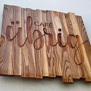 Schild aus Holz geschnitzt mit dem Schriftzug "übrig"