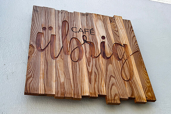 Schild aus Holz geschnitzt mit dem Schriftzug "übrig"