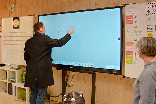 Spaß an der digitalen Technik: OB Tobias Eschenbacher setzt schwungvoll seine Unterschrift auf ein interaktives Whiteboard – mit dem Finger. (Foto: Stadt Freising)