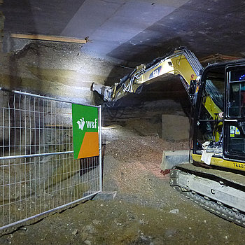 Ein Bagger gräbt sich in die Mauer, die den Tunnel Nord und Süd - noch - trennt. (Foto: Martin Bullinger/edr)