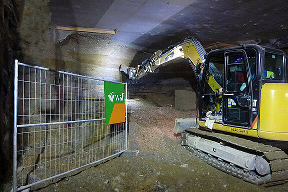Ein Bagger gräbt sich in die Mauer, die den Tunnel Nord und Süd - noch - trennt. (Foto: Martin Bullinger/edr)