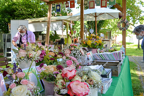 Dieser Stand bot rosige Blumenkränze, -sträuße und -gestecke beim Rosentag 2021 im Amtsgerichtsgarten Freising. (Foto: Stadt Freising)