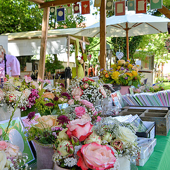 Dieser Stand bot rosige Blumenkränze, -sträuße und -gestecke beim Rosentag 2021 im Amtsgerichtsgarten Freising. (Foto: Stadt Freising)