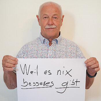 Stadtratsmitglied Benno Zierer. Foto: Stadt Freising Ein Mann in einem weißen Hemd zeigt ein Schild mit der Aufschrift "weil es nichts besseres gibt"