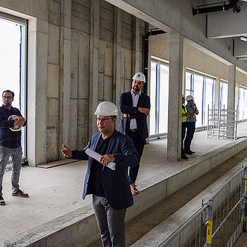 Architekt Arnd Rudolph (Vordergrund) informiert über die Zusatzausstattung der Turnhalle als Veranstaltungsstätte. (Foto: Stadt Freising)