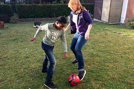 Balu und Mogli spielen zusammen Fußball.