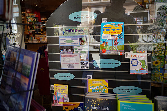 Ein Fenster mit vielen Büchern und einem Plakat