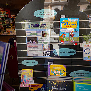 Ein Fenster mit vielen Büchern und einem Plakat