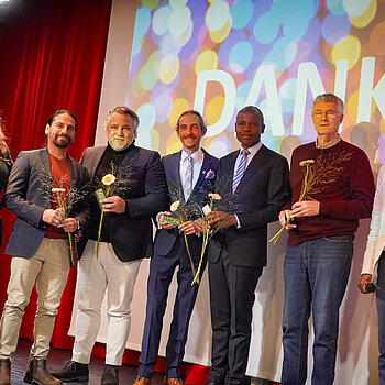 Auf dem Bild ist die Jury vom Interkulturellen Preis 2025 zu sehen: Michaela John, Mauricio Tercero, Sebastian Wanzke, Jürgen Mieskes, Samuel Fosso, Jochen Hauer und Sem Haikali.