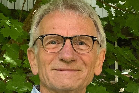 Ein Mann mit Brille vor Pflanzen