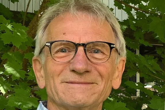 Ein Mann mit Brille vor Pflanzen